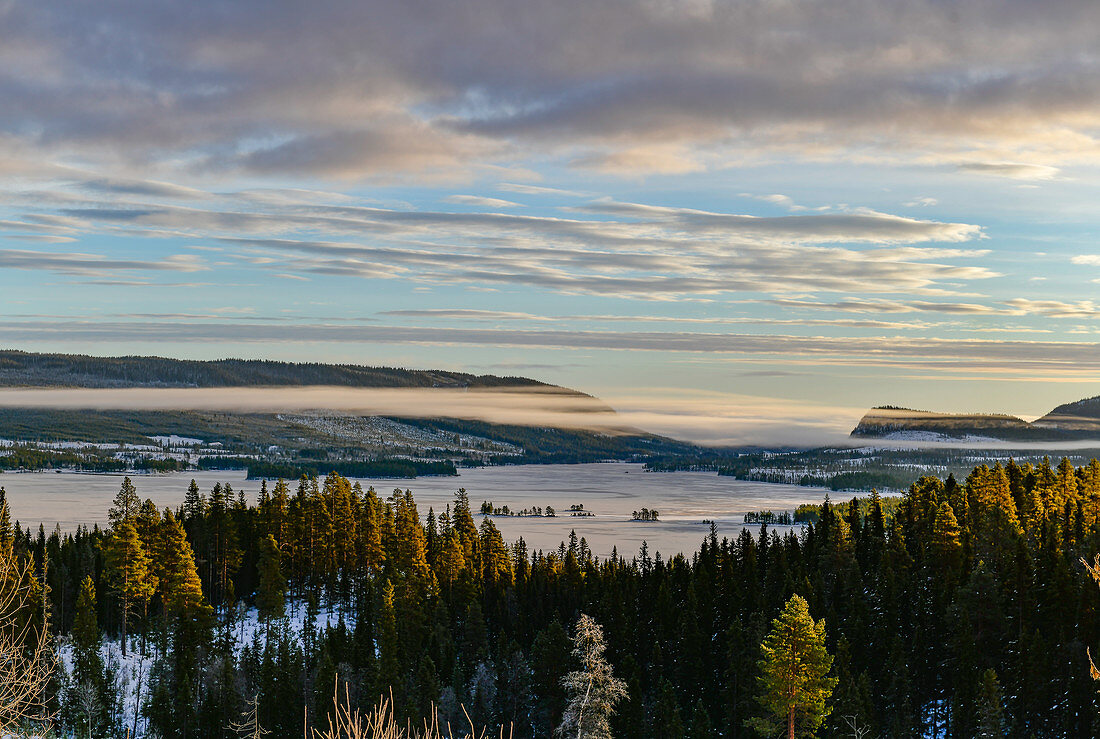 Blick über Berge und ein Tal mit Nebel im Winter, Asele, Lappland, Schweden