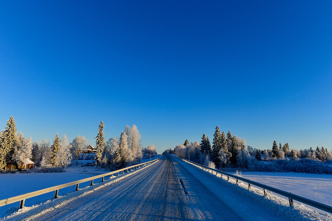 Eis auf einer Strasse im tiefen Winter bei Lycksele, Västerbottens Län, Schweden
