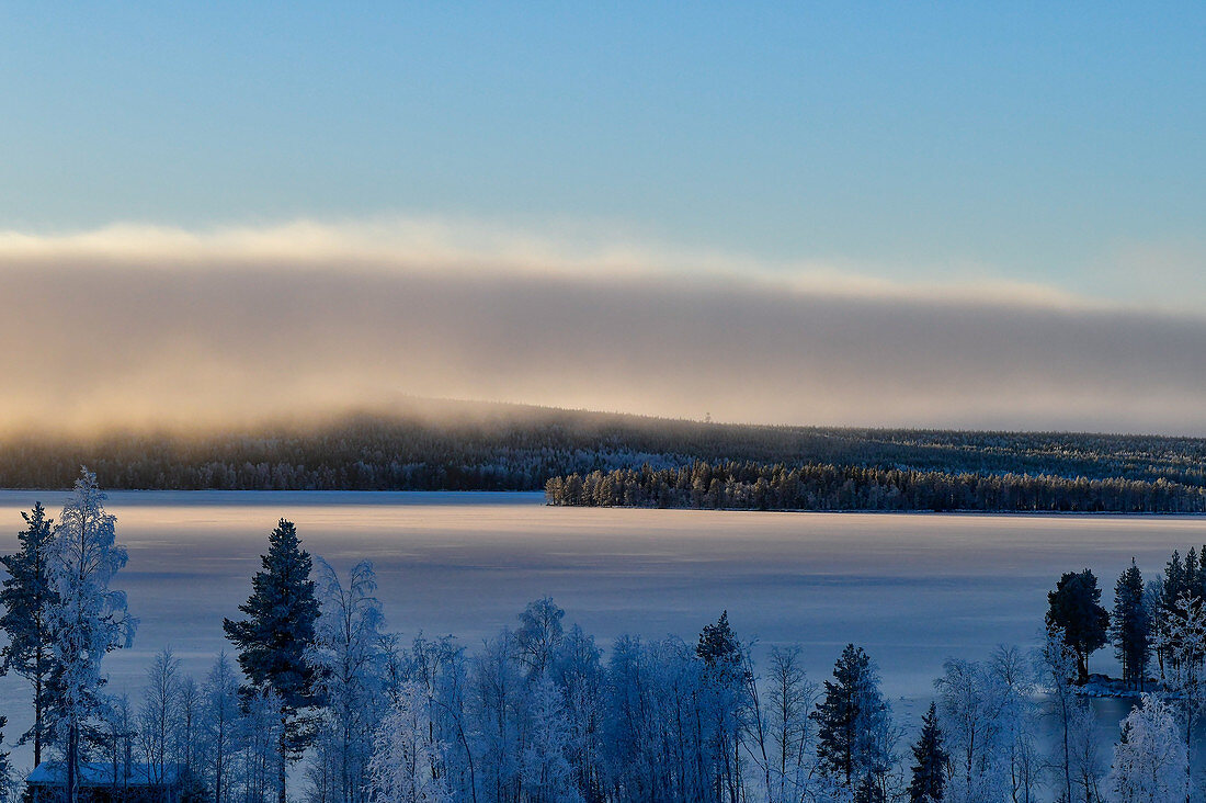 Wall of clouds and a view of a lake and snowy forest near Dorotea, Lapland, Sweden