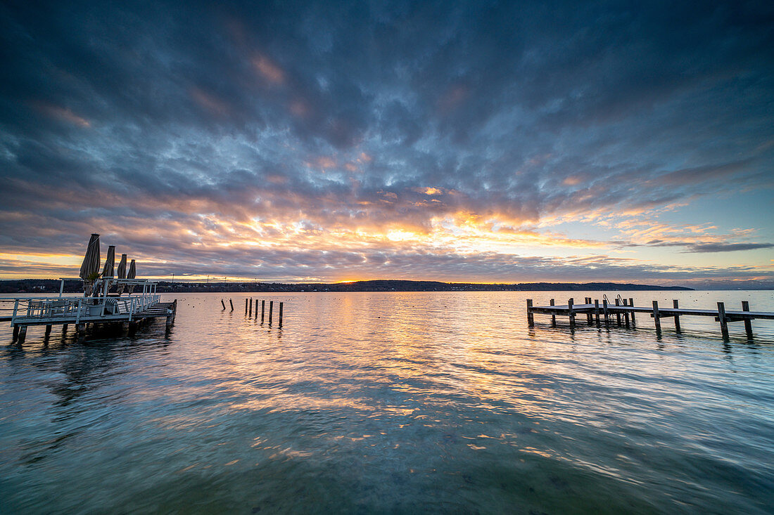 Sunrise on the promenade with bathing jetty on the north shore of Lake Starnberg, Starnberg, Bavaria, Germany.