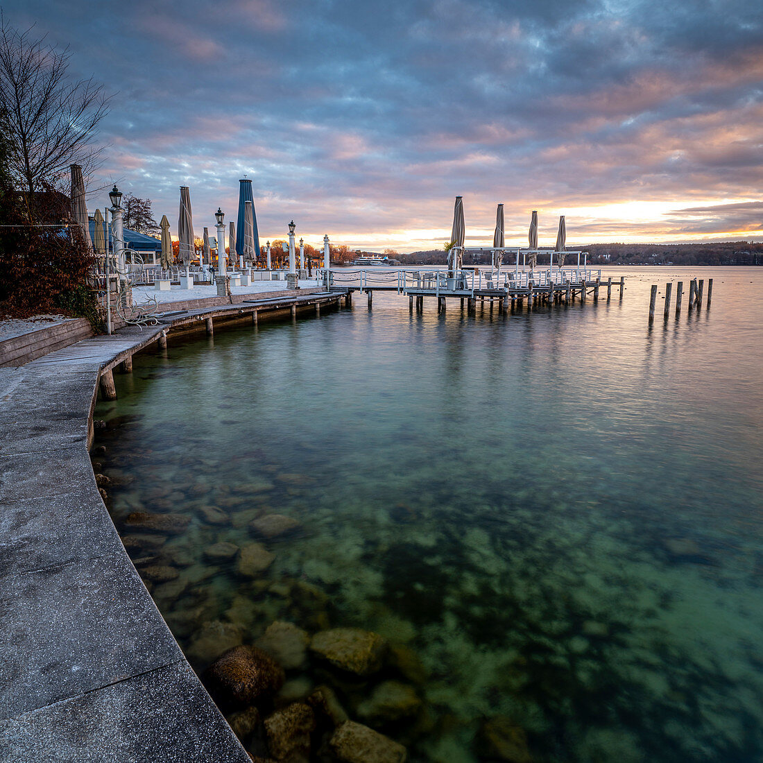 Sunrise on the promenade with a view of the beach bar on the north shore of Lake Starnberg, Starnberg, Bavaria, Germany.