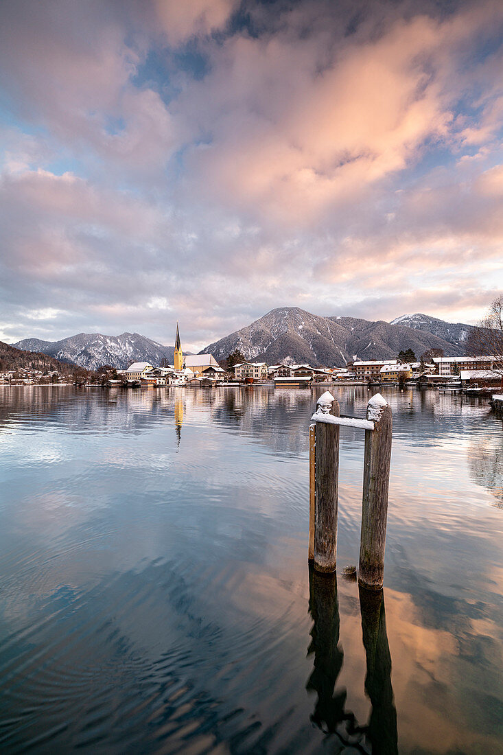 View over the wintry Tegernsee to the village of Rottach-Egern with the church Sankt Laurentius, Bavaria, Germany.