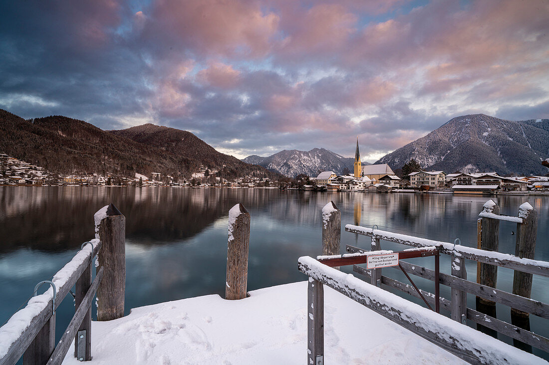 View over the wintry Tegernsee to the village of Rottach-Egern with the church Sankt Laurentius, Bavaria, Germany.