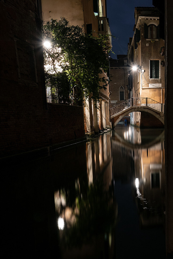 Blick auf einen kleinen Kanal mit mit Brücke und Booten am Abend in San Marco, Venedig, Venetien, Italien, Europa