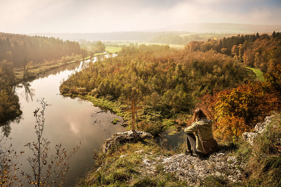 young woman sitting looks to the Braunsel, which flows into the Danube, Rechtenstein, view from Hochwartfelsen, Alb-Donau district, Swabian Alb, Baden-Württemberg, Germany