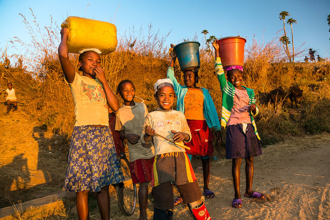 Children come from fetching water, at Ampefy, Merina tribe, highlands, Madagascar, Africa
