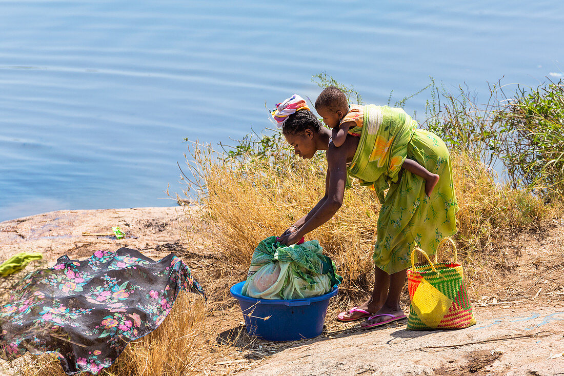 Woman with baby washing clothes by the river, Southern Madagascar, Africa