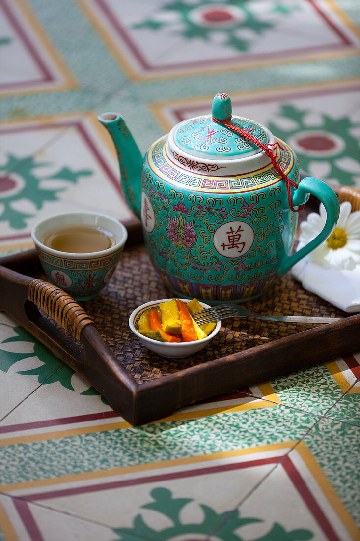 Chinese tea arrangement set on a Nonya style, tile floor. Malacca, Malaysia.