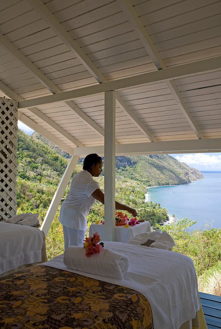 Spa-Therapeut bereitet Blumen in einer weißen Cabana mit erweitertem Meerblick vor. St. Lucia, Westindische Inseln.