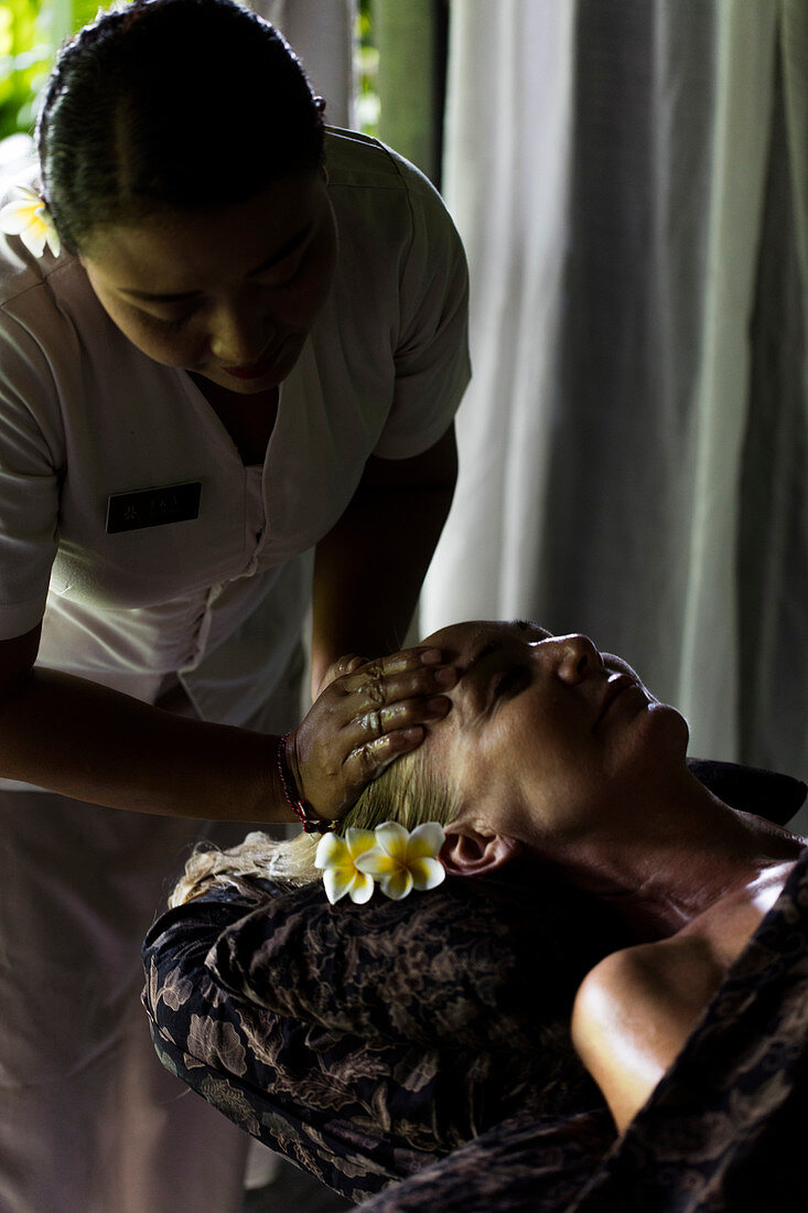 Gesichtsmassage an Frau von balinesischen Therapeuten durchgeführt. Bali, Indonesien.