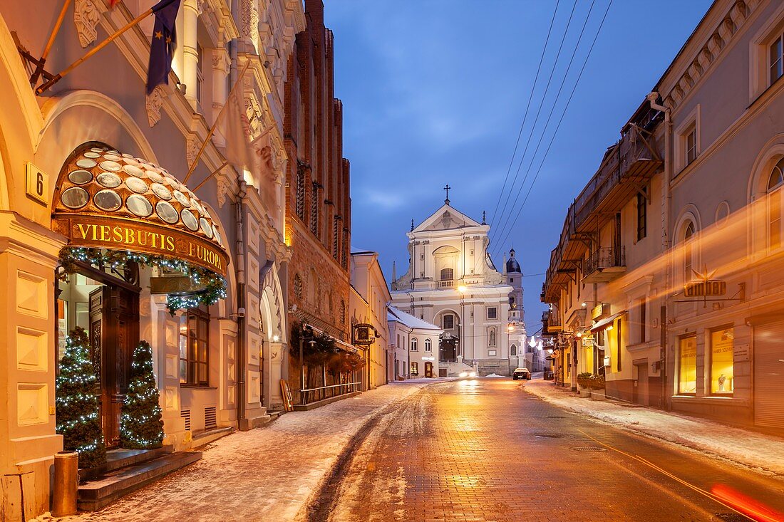 Winteranbruch in der Altstadt von Vilnius, Litauen. Barocke St. Teresa Kirche in der Ferne.