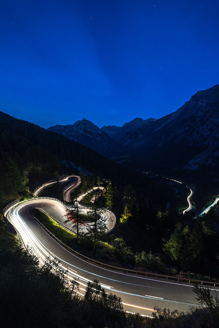 Leichte Pfade auf den Haarnadelkurven der Maloja-Pass-Bergstraße bei Nacht, Engadin, Kanton Graubunden, Schweiz, Europa