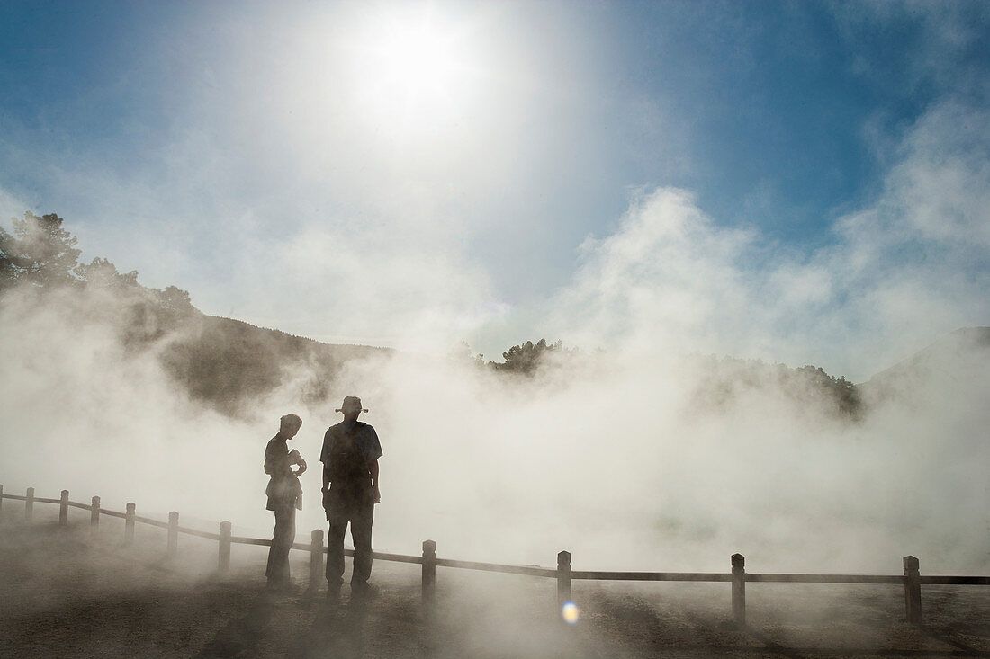 Zwei Personen im aufsteigenden Nebel an einem Thermal-Pool