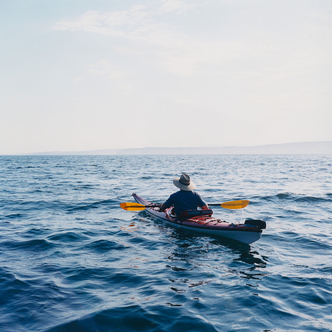 Mann fährt Kajak in Puget Sound in der Abenddämmerung