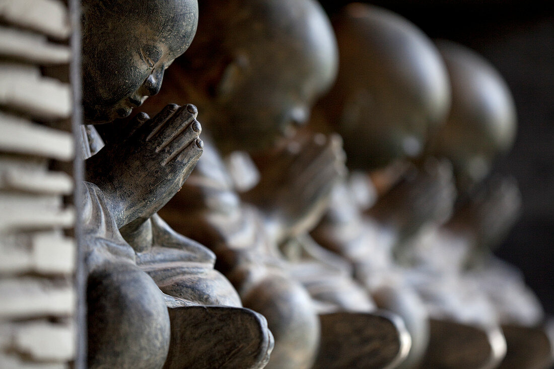 A row of Bhudda statues made in polished concrete. Bali