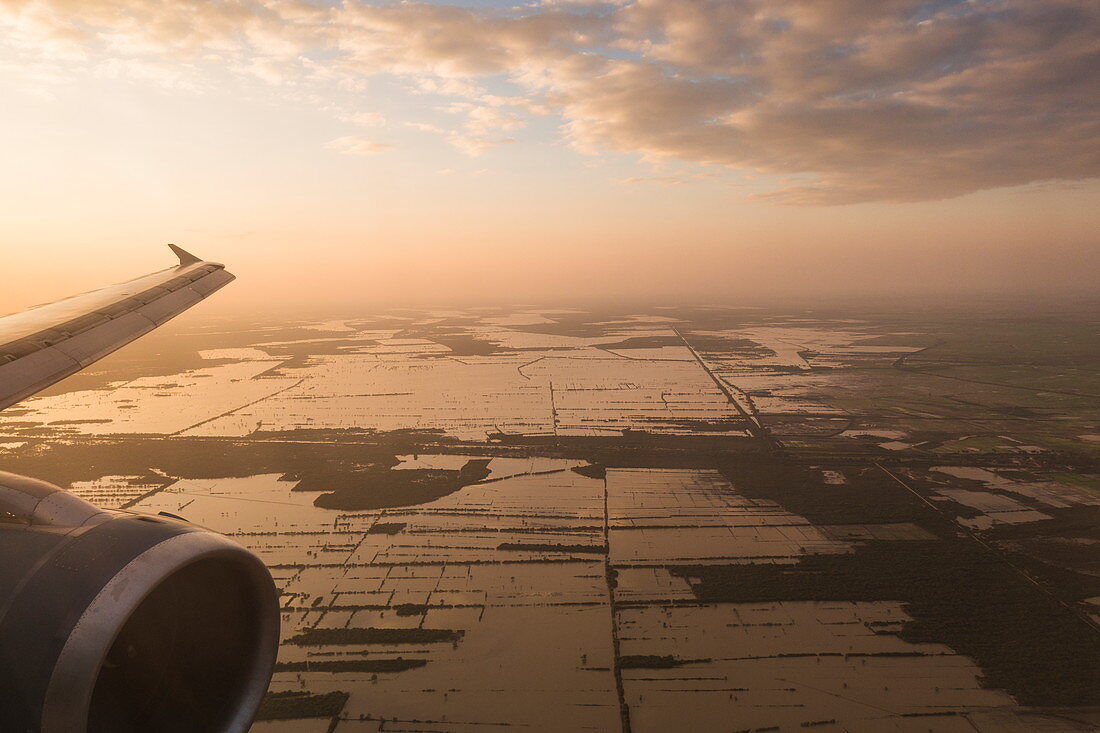 Luftaufnahme von Tragfläche eines Vietnam Airlines Airbus A-320 Flugzeug mit Blick auf überflutete Felder bei Sonnenuntergang, nahe Siem Reap, Siem Reap Province, Kambodscha, Asien