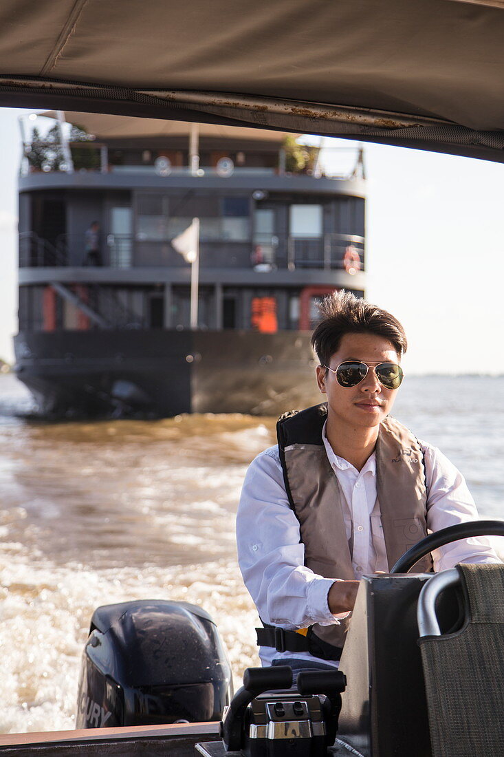Fahrer steuert Skiff Beiboot von Flusskreuzfahrtschiff auf dem Fluss Tonle Sap, Kampong Prasat, Kampong Chhnang, Kambodscha, Asien