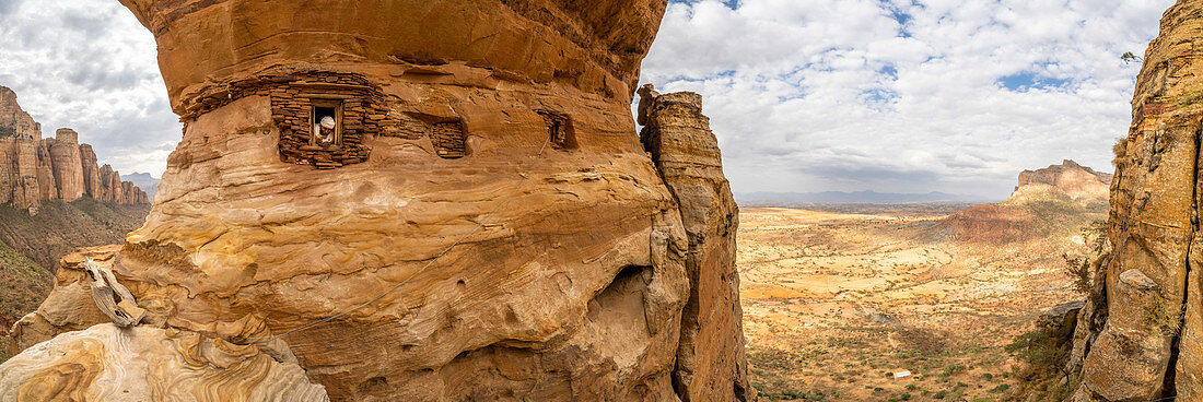 Aerial panoramic by drone of priest looking out from Abuna Yemata Guh rock-hewn church, Gheralta Mountains, Tigray region, Ethiopia, Africa