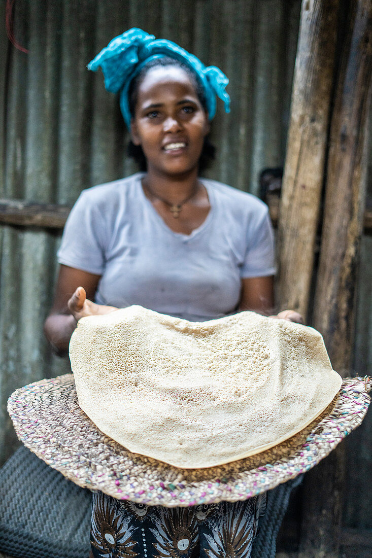 Frau, die das traditionelle Injera-Fladenbrot, Berhale, Afar Region, Äthiopien, Afrika zeigt
