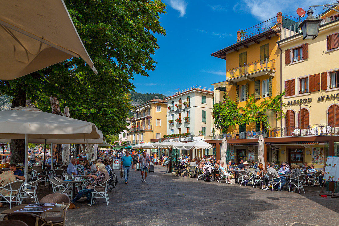 Ansicht von Cafés und Besuchern auf der Promenade an einem sonnigen Tag, Gardasee, Gardasee, Provinz Verona, Venetien, italienische Seen, Italien, Europa