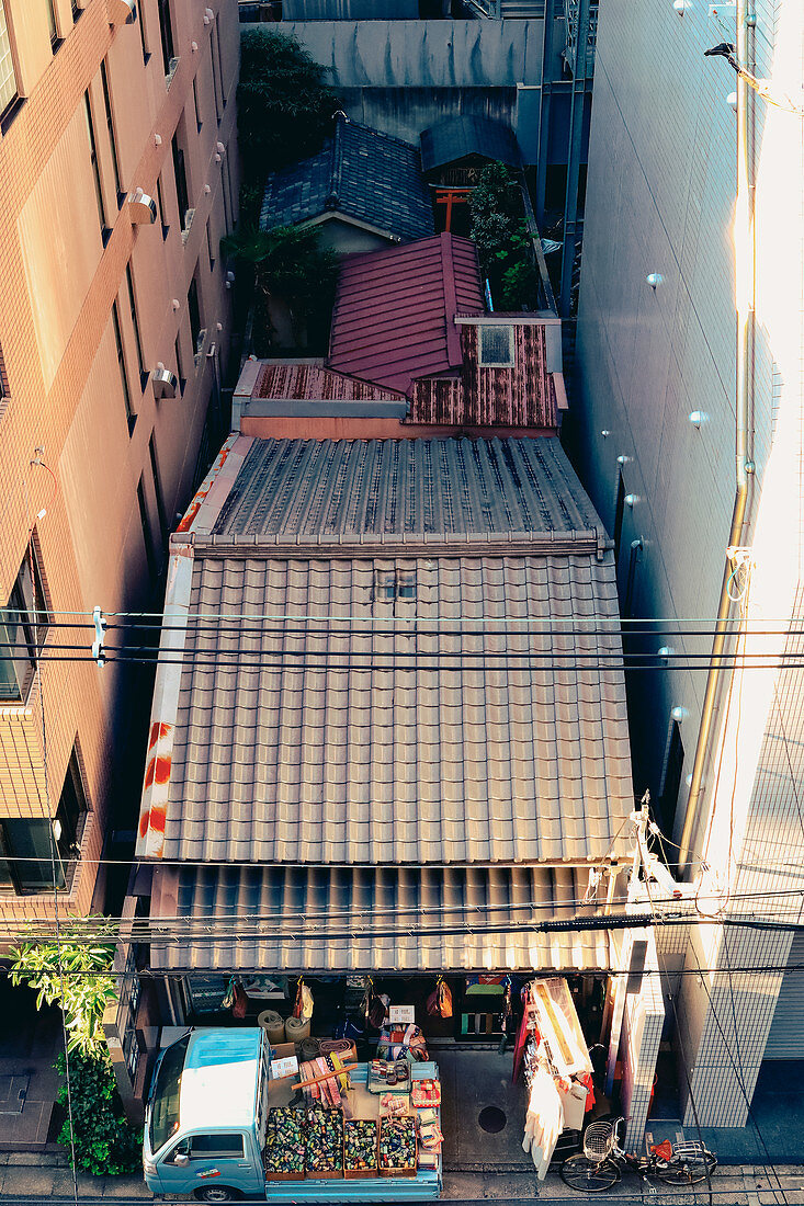 A bird's eye view of a textiles shop in Kyoto with a small delivery truck, Japan