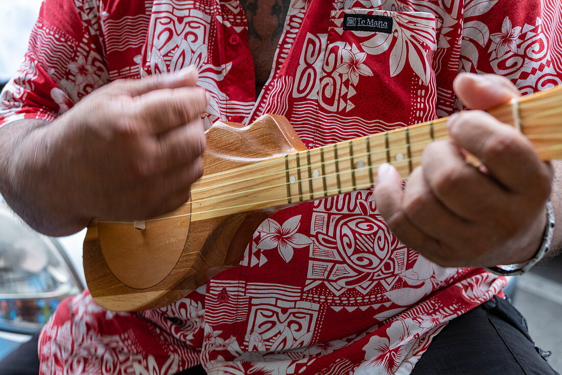 Tahitianischer Mann spielt Ukulele Gitarre bei einem Kulturfestival, Papeete, Tahiti, Windward Islands, Französisch-Polynesien, Südpazifik