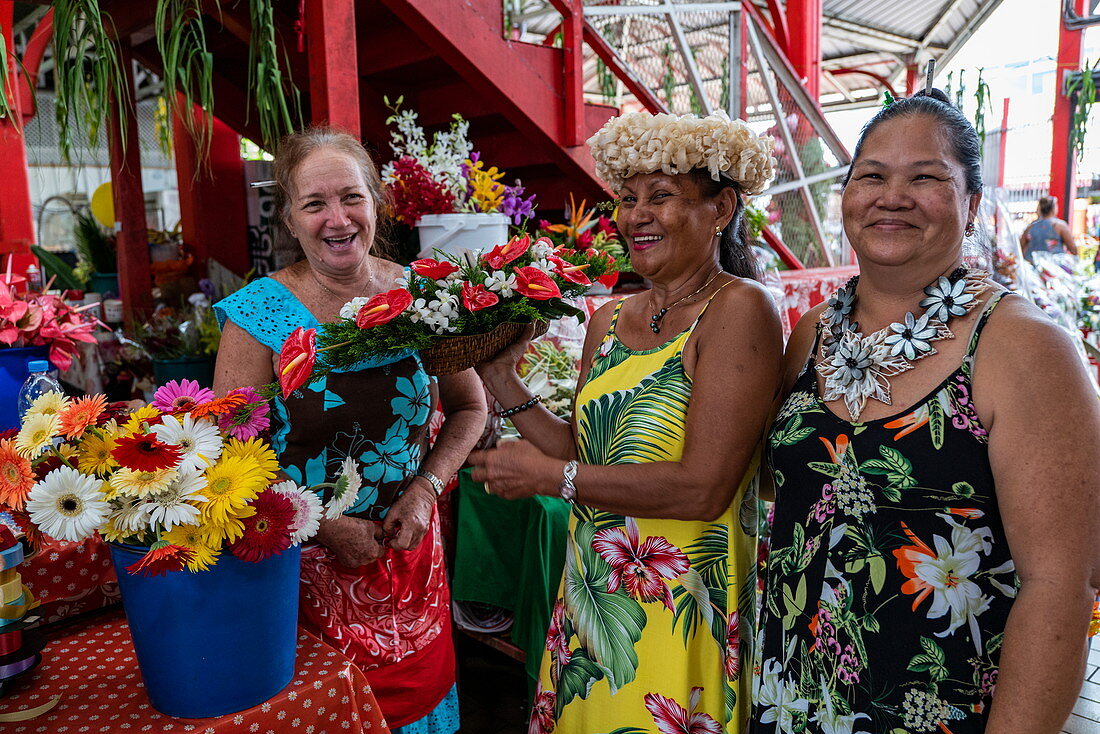 Three Tahitian women at a flower stand in the 'Marché Papeete' market hall, Papeete, Tahiti, Windward Islands, French Polynesia, South Pacific