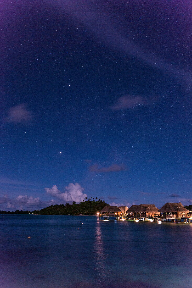 Überwasserbungalows des Sofitel Bora Bora Private Island Resort in der Lagune von Bora Bora mit Kreuz des Südens im Sternenhimmel bei Nacht, Bora Bora, Leeward Islands, Französisch-Polynesien, Südpazifik