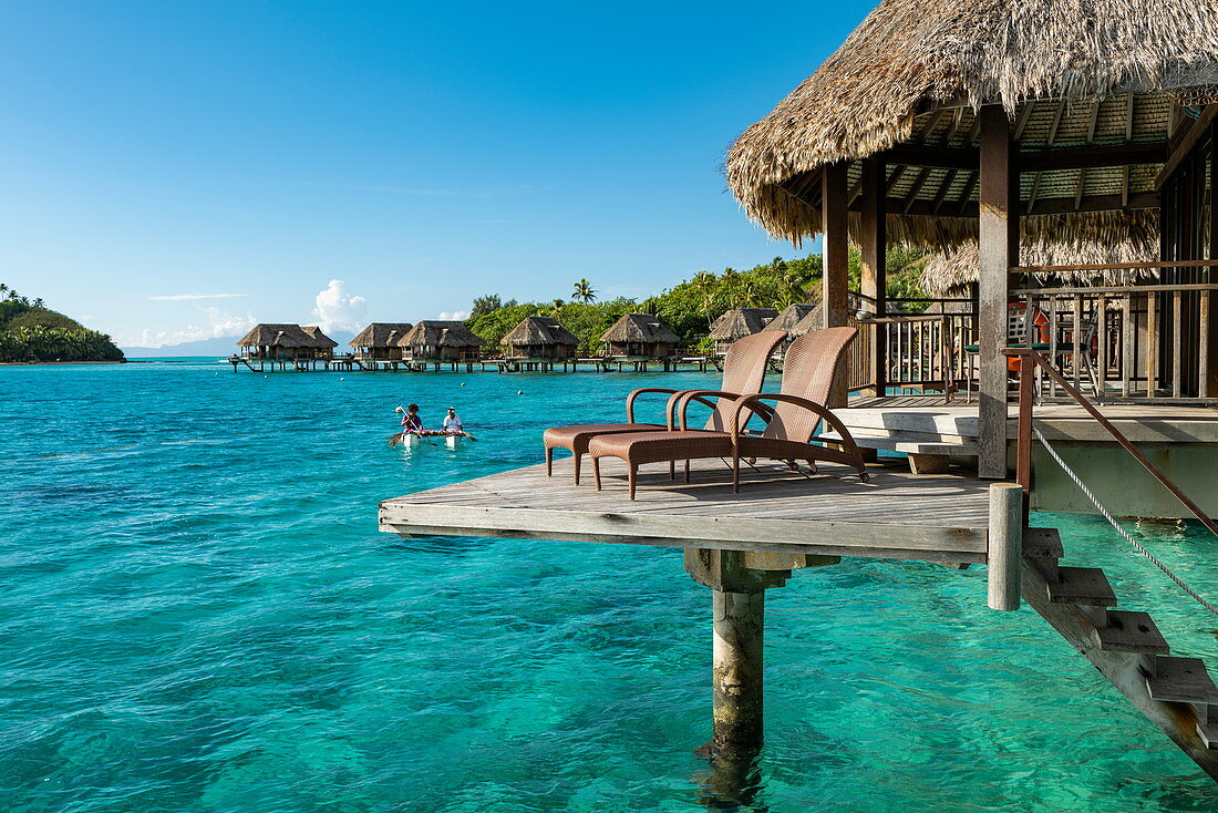 Frühstück wird mit einem Pirogue Auslegerkanu zu einem Überwasserbungalow des Sofitel Bora Bora Private Island Resorts in der Lagune von Bora Bora gebracht, Bora Bora, Leeward Islands, Französisch-Polynesien, Südpazifik