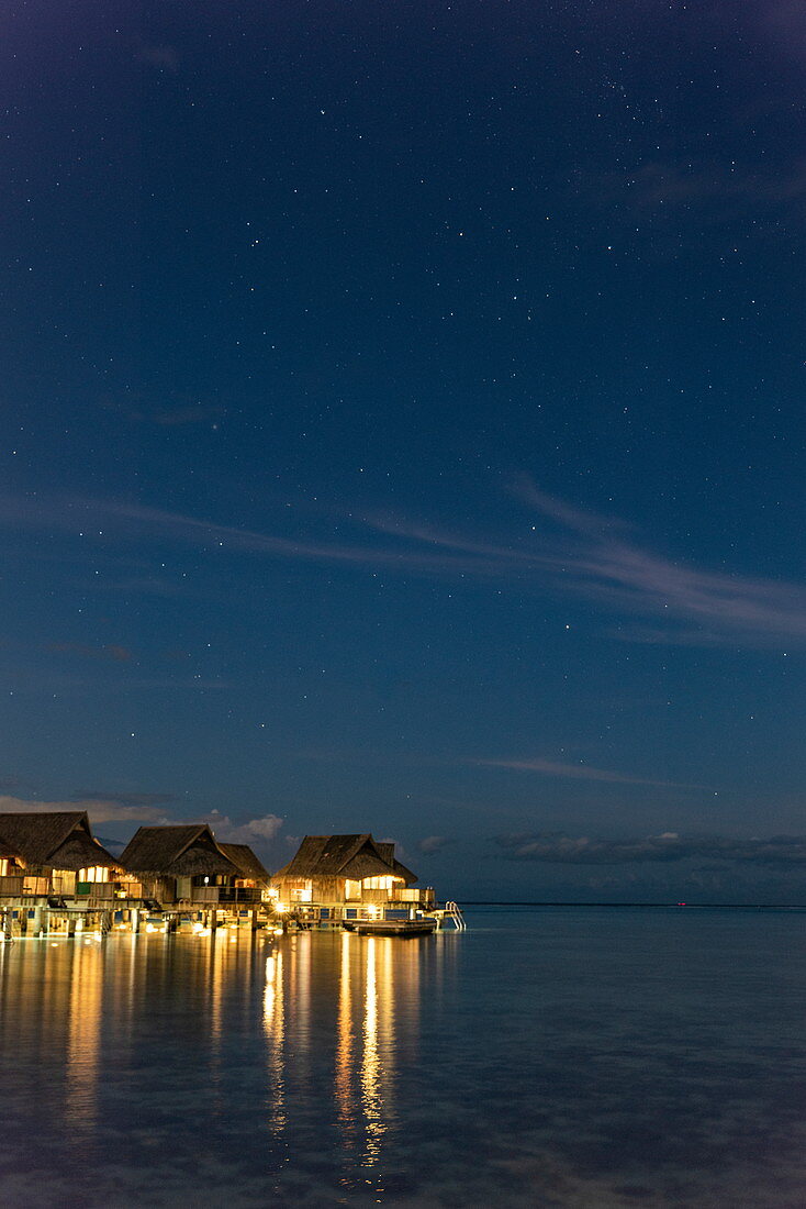 Overwater bungalows of the Sofitel Ia Ora Beach Resort in the lagoon of Moorea with the Southern Cross in the starry sky at night, Moorea, Windward Islands, French Polynesia, South Pacific