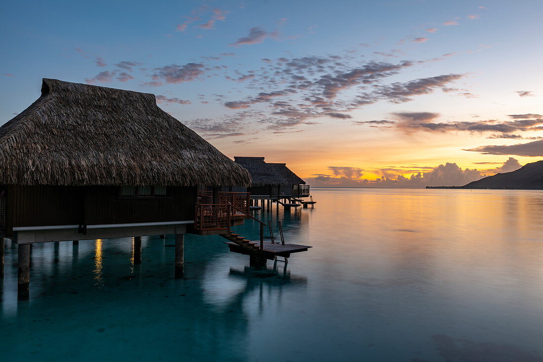 Überwasserbungalows des Hilton Moorea Lagoon Resort & Spa bei Sonnenaufgang, Moorea, Windward Islands, Französisch-Polynesien, Südpazifik