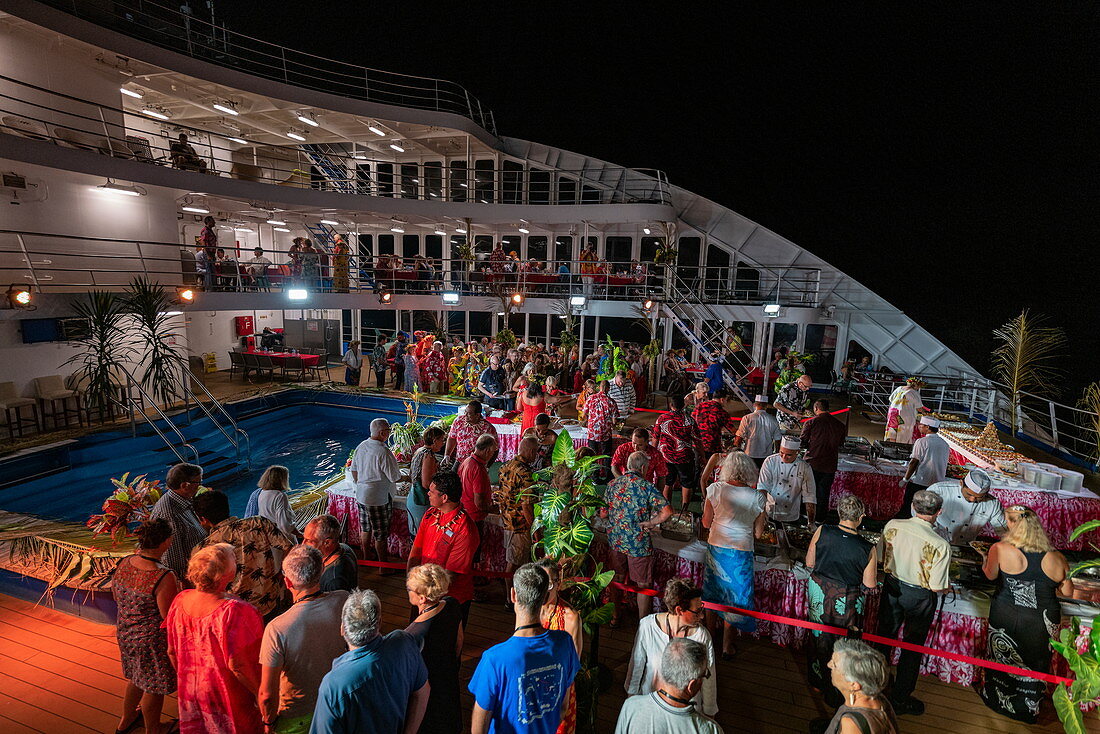 Die Passagiere von Passagierfrachtschiff Aranui 5 (Aranui Cruises) genießen einen polynesischen Abend mit einem reichhaltigen Buffet und kultureller Unterhaltung, auf See nahe den Marquesas-Inseln, Französisch-Polynesien, Südpazifik