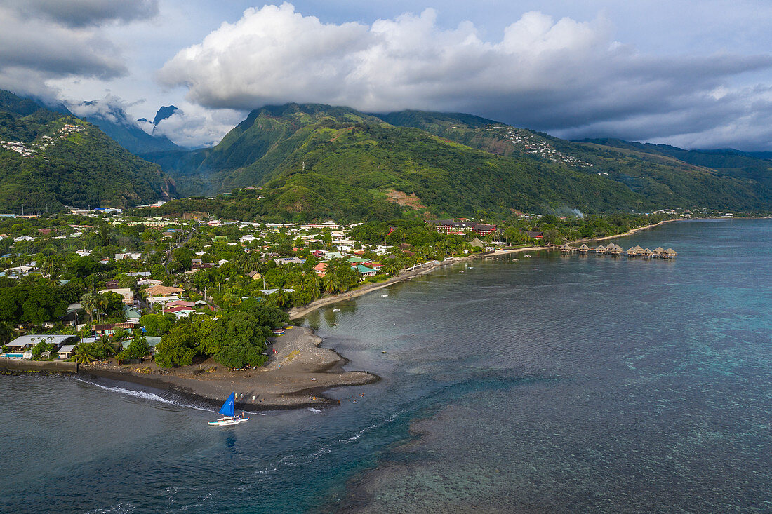 Luftaufnahme von Auslegerkanu mit Segel am Strand mit Küste und Bergen dahinter, Nuuroa, Tahiti, Windward Islands, Französisch-Polynesien, Südpazifik