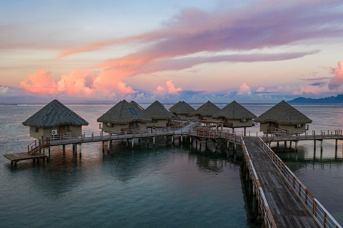 Luftaufnahme der Überwasserbungalows im Tahiti Ia Ora Beach Resort (managed by Sofitel) bei Sonnenuntergang, nahe Papeete, Tahiti, Windward Islands, Französisch-Polynesien, Südpazifik