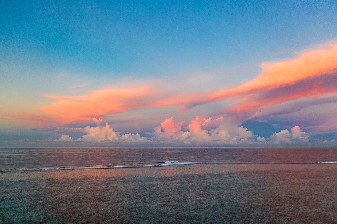 Luftaufnahme von Wellen die am Riff brechen mit Sonnenuntergangswolken dahinter, nahe Papeete, Tahiti, Windward Islands, Französisch-Polynesien, Südpazifik