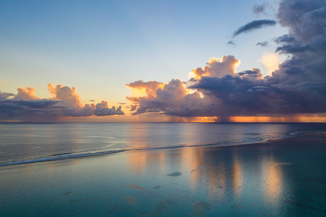 Aerial view of sunset clouds with rain showers along the Moorea Lagoon, Avamotu, Moorea, Windward Islands, French Polynesia, South Pacific