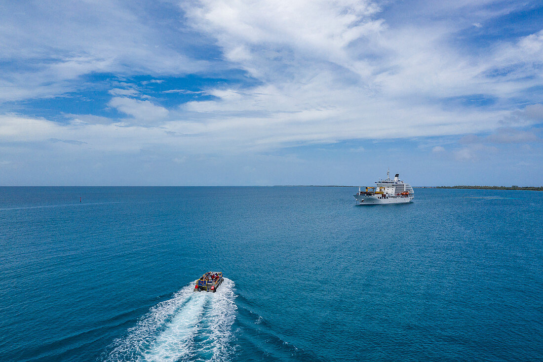 Luftaufnahme von Passagieren auf Beiboot auf dem Weg zurück zum Passagierfrachter Aranui 5 (Aranui Cruises), Rotoava, Fakarava-Atoll, Tuamotu-Inseln, Französisch-Polynesien, Südpazifik