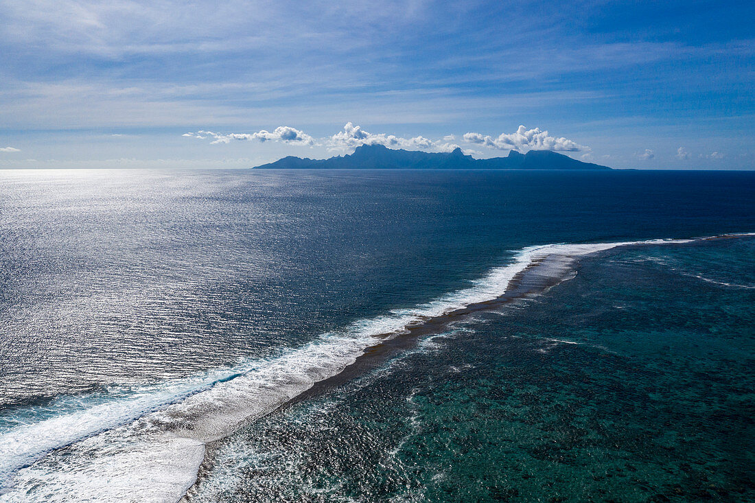 Aerial view of the reef that separates the lagoon from the South Pacific with Moorea Island in the distance, near Papeete, Tahiti, Windward Islands, French Polynesia, South Pacific