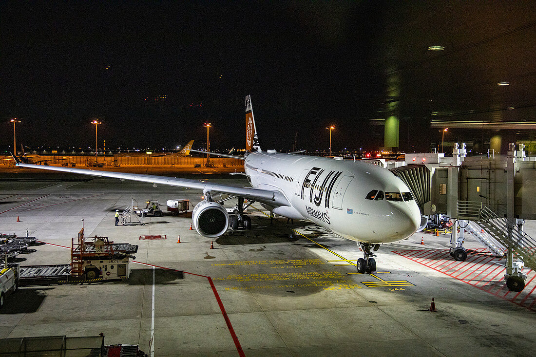 Fiji Airways Airbus A330-200 airplane called &quot;Island of Vatulele&quot; at a gate at Singapore Changi Airport at night, Singapore, Singapore, Asia