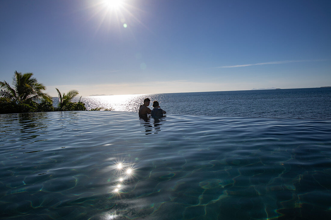 Menschen entspannen sich im Infinity Pool im Malamala Island Beach Club, Mala Mala Island, Mamanuca Group, Fidschi-Inseln, Südpazifik