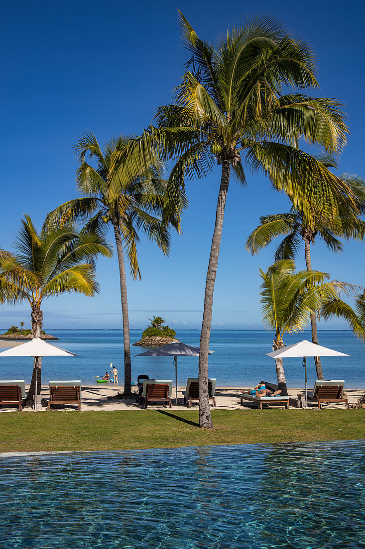 Swimming Pool, Liegestühle und Kokospalmen im Six Senses Fiji Resort, Malolo Island, Mamanuca Group, Fidschi-Inseln, Südpazifik