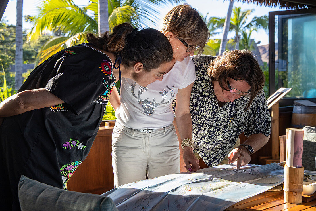 Menschen schauen auf Landkarte der fidschianischen Inseln während ihres Aufenthaltes im Six Senses Fiji Resort, Malolo Island, Mamanuca Group, Fidschi-Inseln, Südpazifik