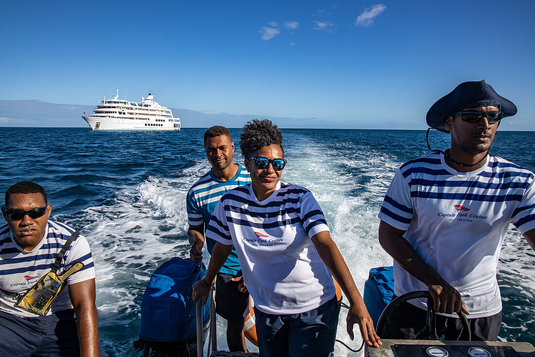Vier Besatzungsmitglieder von Kreuzfahrtschiff MV Reef Endeavour (Captain Cook Cruises Fiji) auf dem Tender Transferboot, nahe Yangetta Island, Yasawa Group, Fidschi-Inseln, Südpazifik