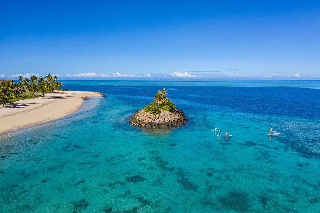 Luftaufnahme von Familie die Wassersport Aktivitäten neben kleiner vorgelagerter Insel im Six Senses Fiji Resort genießt, Malolo Island, Mamanuca Group, Fidschi-Inseln, Südpazifik