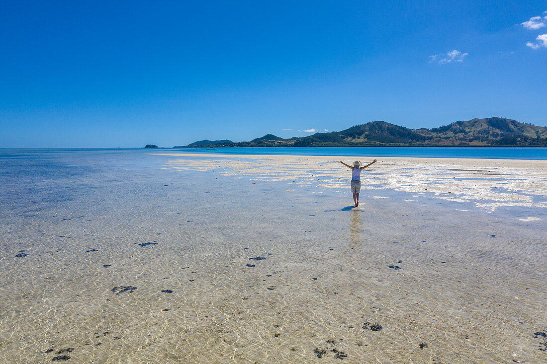 Luftaufnahme von Frau alleine auf Sandbank während eines Bootsausfluges vom Six Senses Fiji Resort, Malolo Island, Mamanuca Group, Fidschi-Inseln, Südpazifik