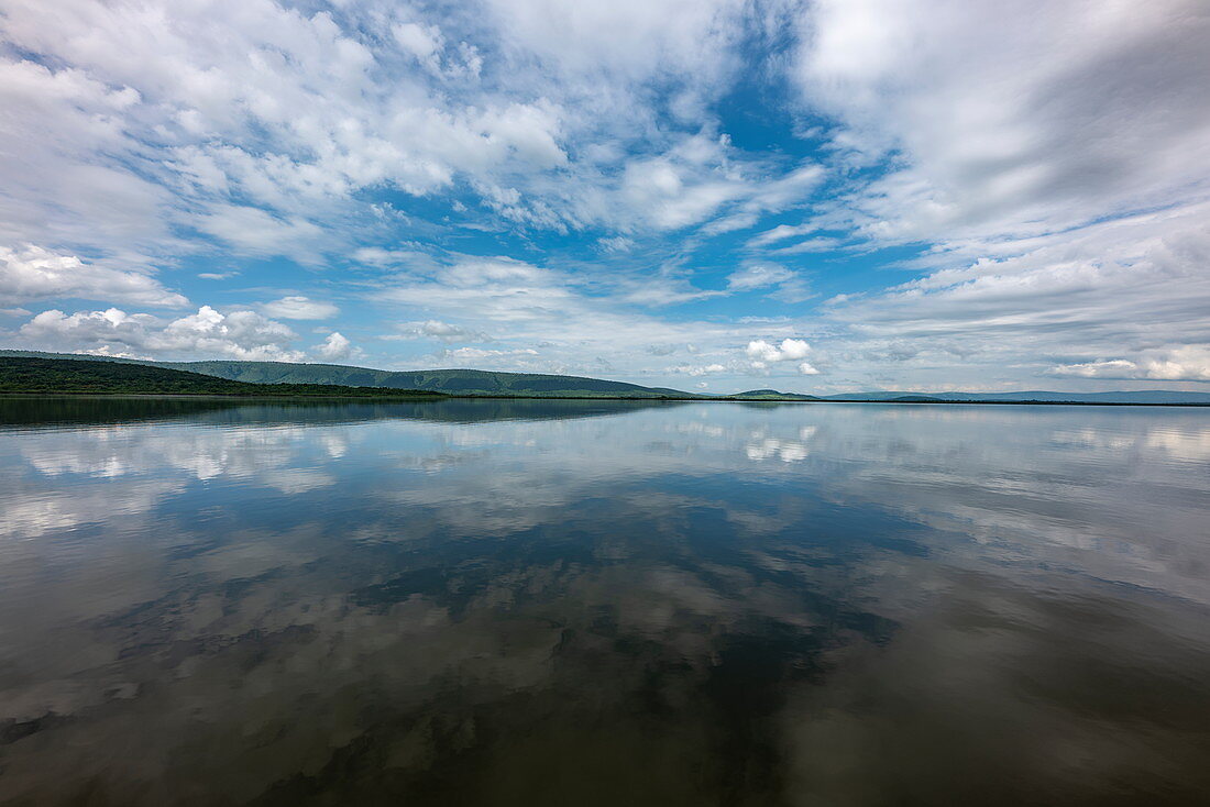 Reflection of clouds in Lake Rwanyakazinga seen from a boat trip from the luxury resort tented camp Magashi Camp (Wilderness Safaris), Akagera National Park, Eastern Province, Rwanda, Africa