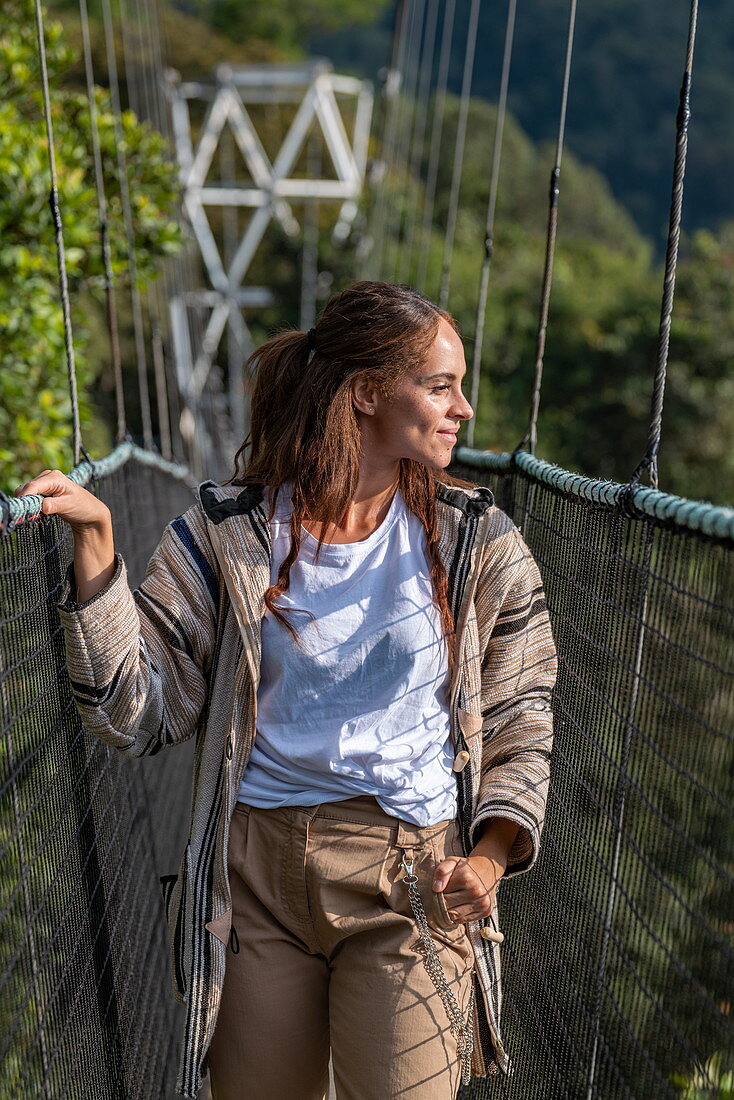 Junge Frau auf Hängebrücke des Canopy Walkway, Nyungwe Forest National Park, Western Province, Ruanda, Afrika