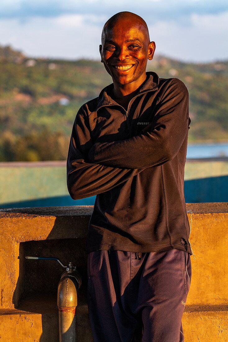 Portrait of a smiling Rwandan man in the late afternoon light, Kinunu, Western Province, Rwanda, Africa