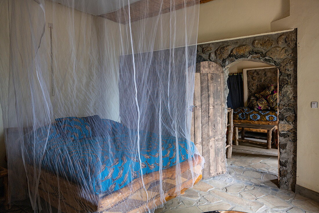 Bed with mosquito net in room at the Kivu Paradis Hotel Resort on the banks of Lake Kivu, Nyamyumba, Western Province, Rwanda, Africa