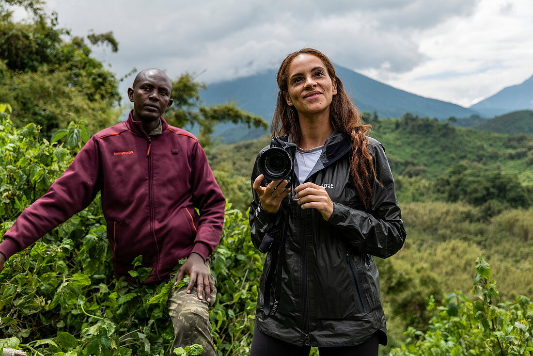 Ranger Guide und junge Frau während eines Trekking Ausflug zur Sabyinyo Gruppe von Gorillas, Volcanoes National Park, Northern Province, Ruanda, Afrika